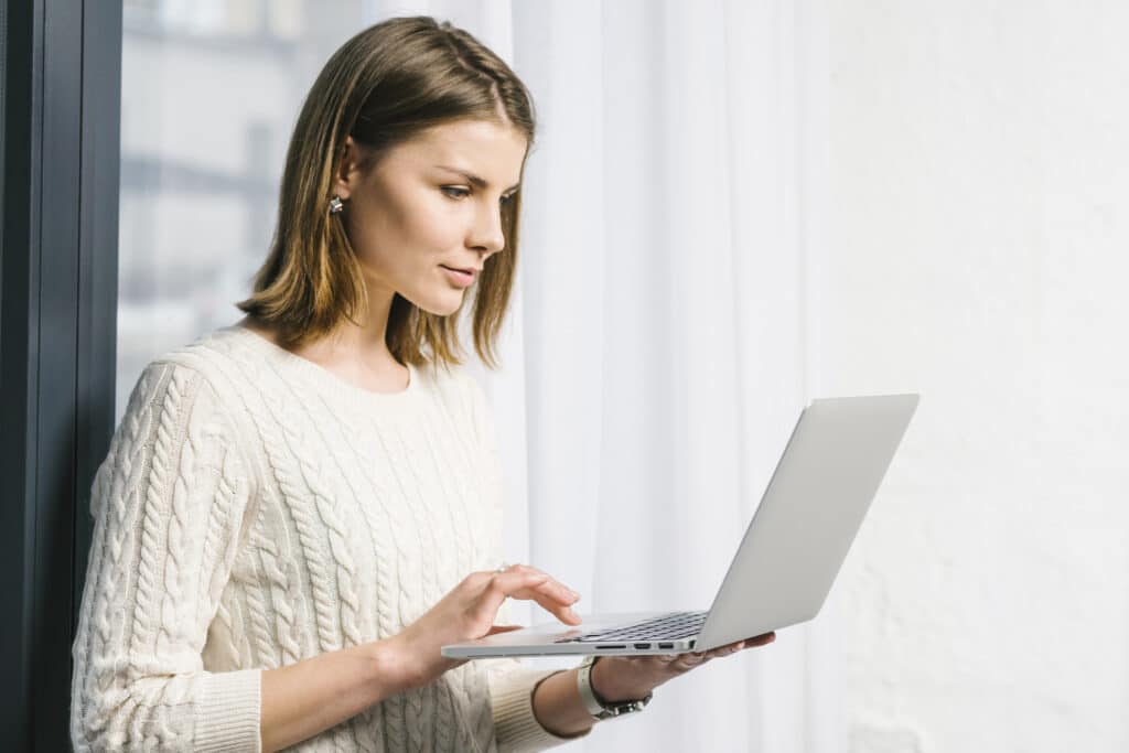 lovely-woman-using-laptop-near-window